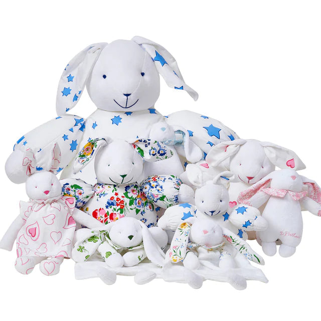 Stack of white stuffed bunnies with colorful patterns on a white background
