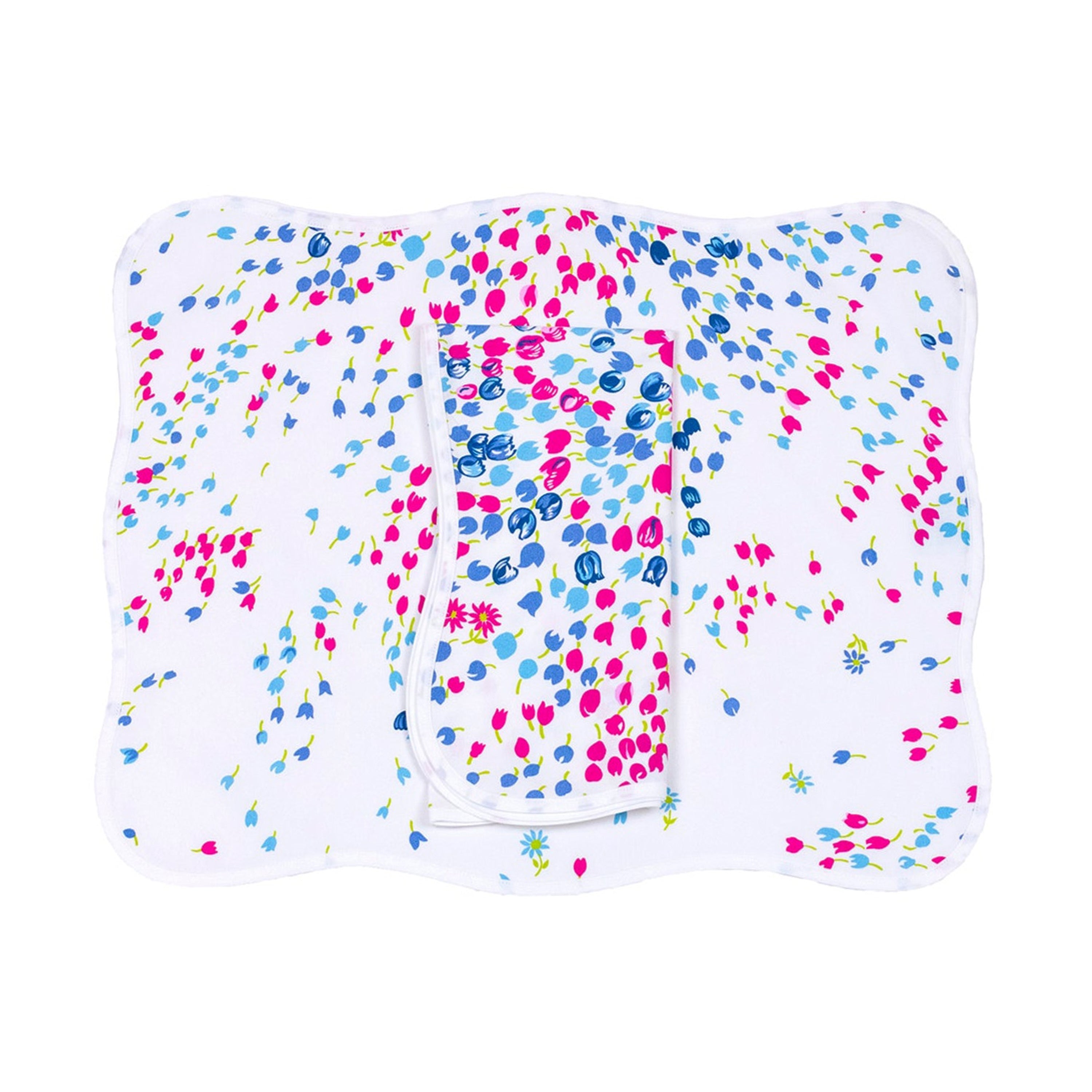 Blue and pink florals, Bouquet Eclate print, shown on placemat with a folded napkin, finished with a wavy white bias, on a white background.