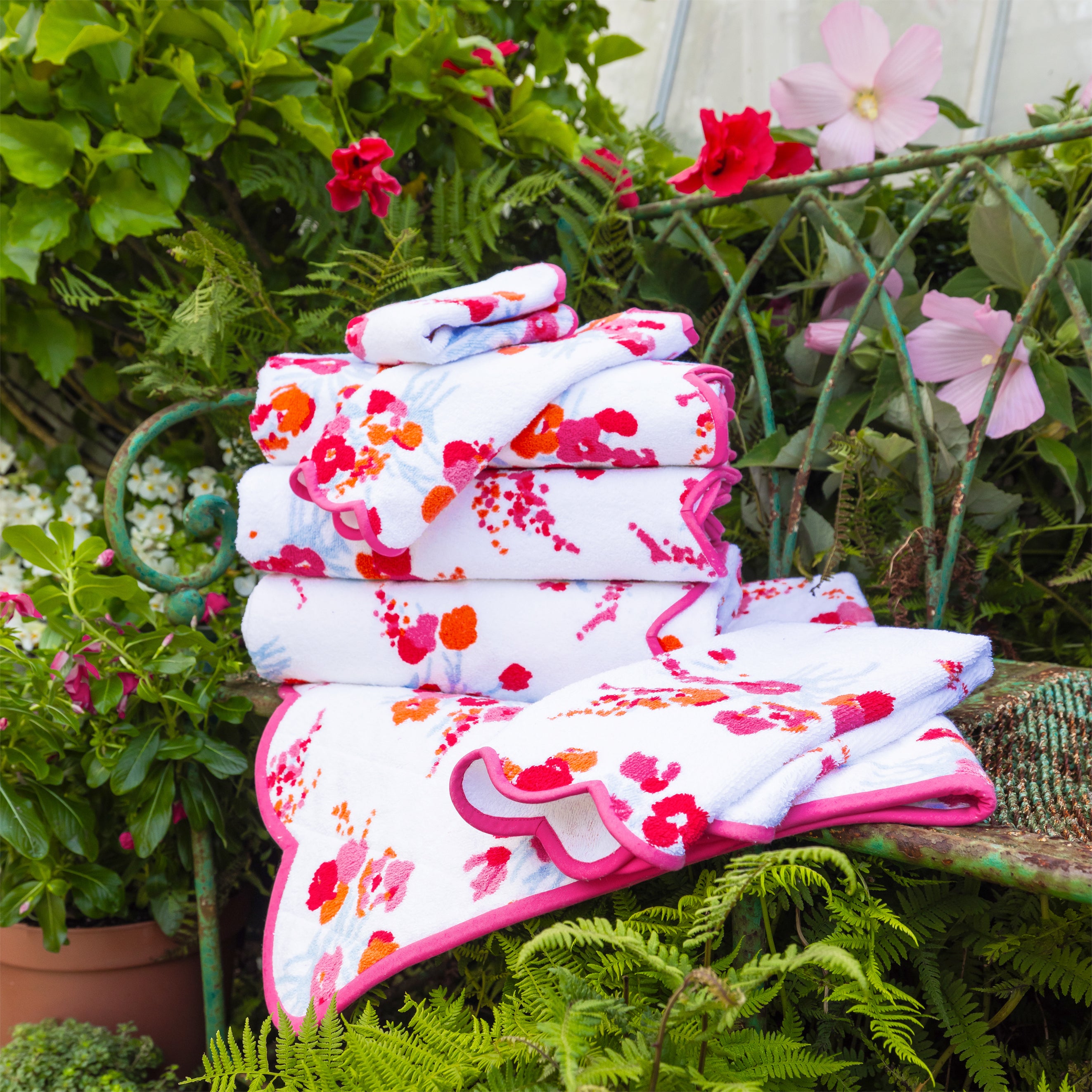 Stack of folded towels with floral pattern on a garden bench
