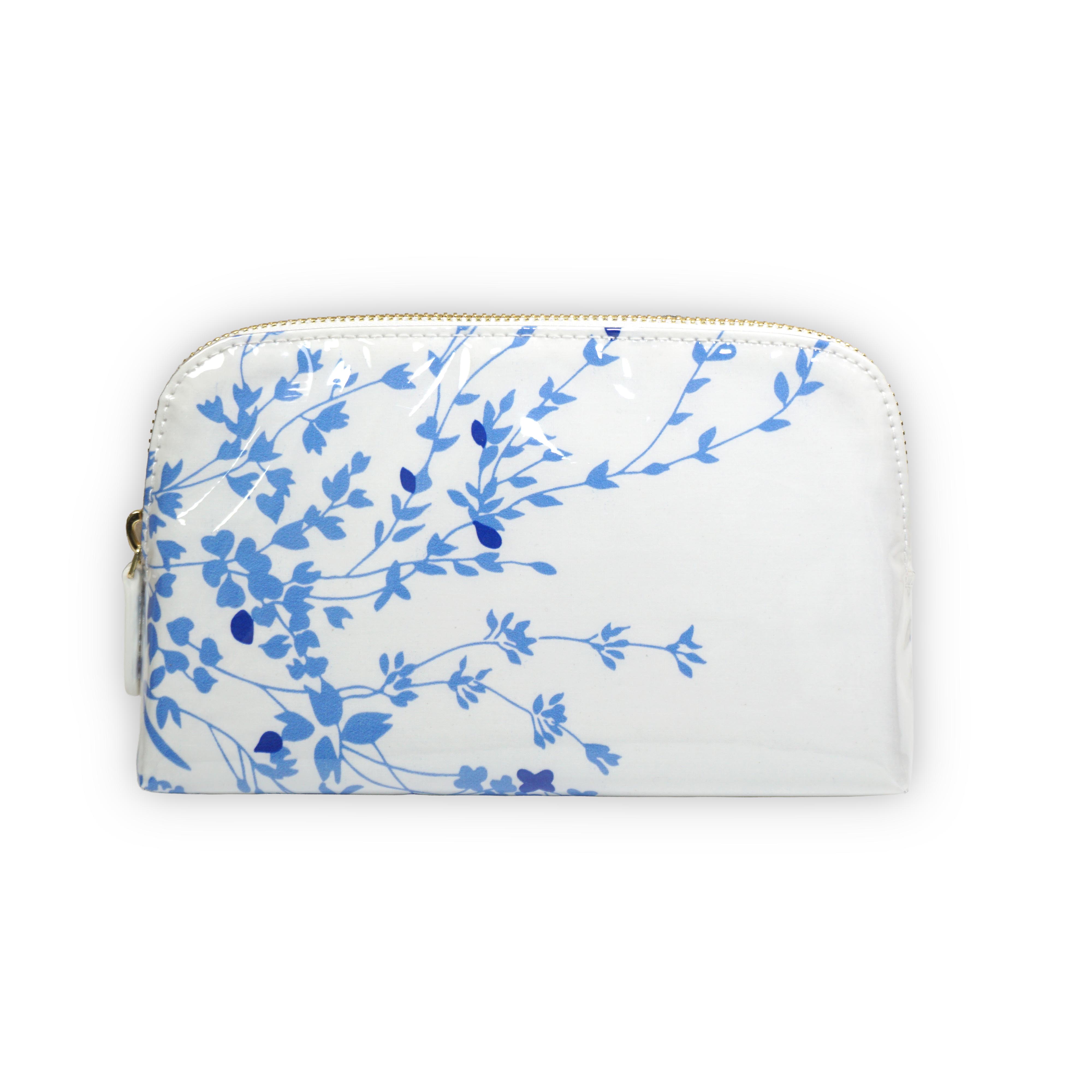 Small white cosmetic pouch featuring blue floral motifs in Jete de Fleurs, finished with a gold-tone brass zip closure.