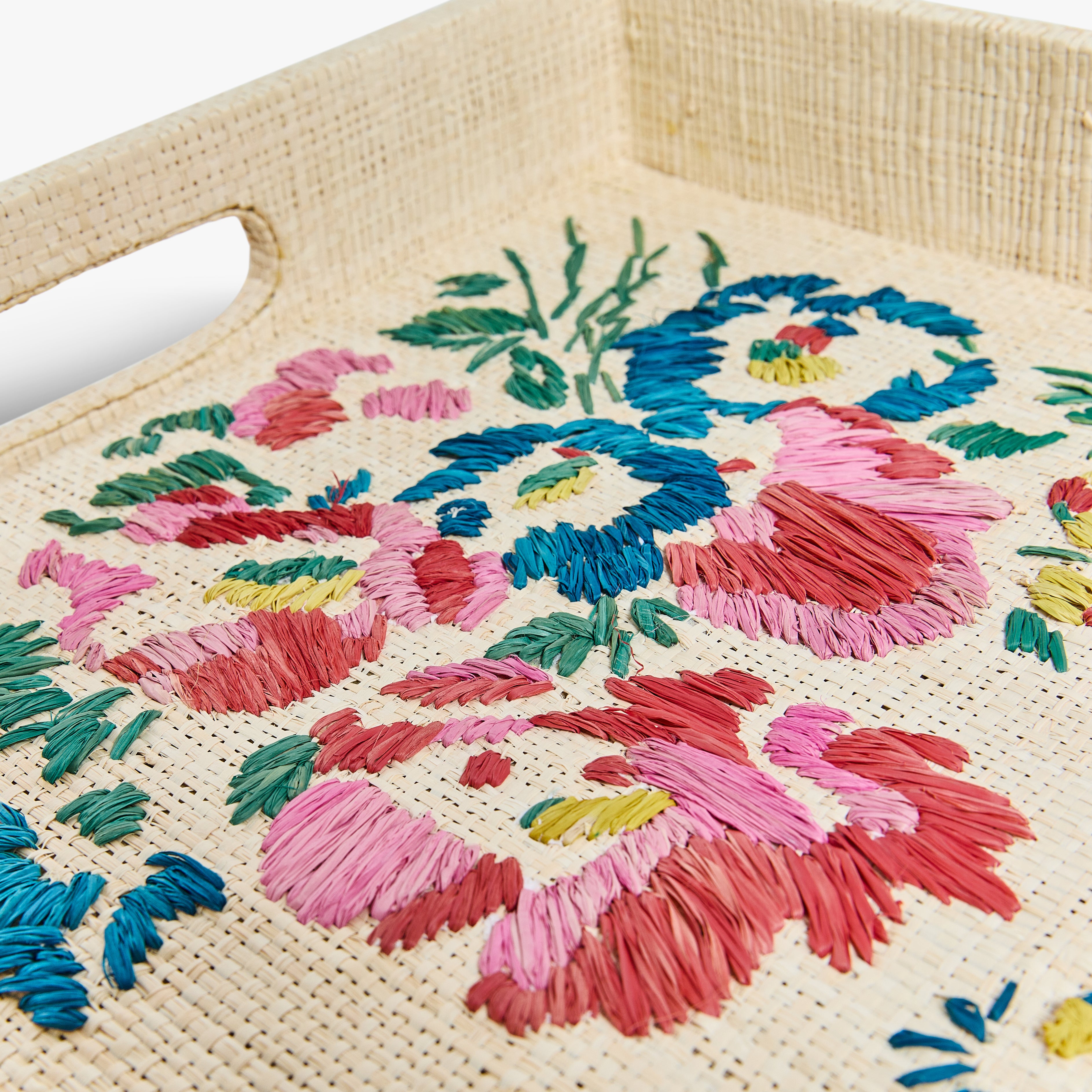 Woven bag with colorful floral embroidery on a beige background