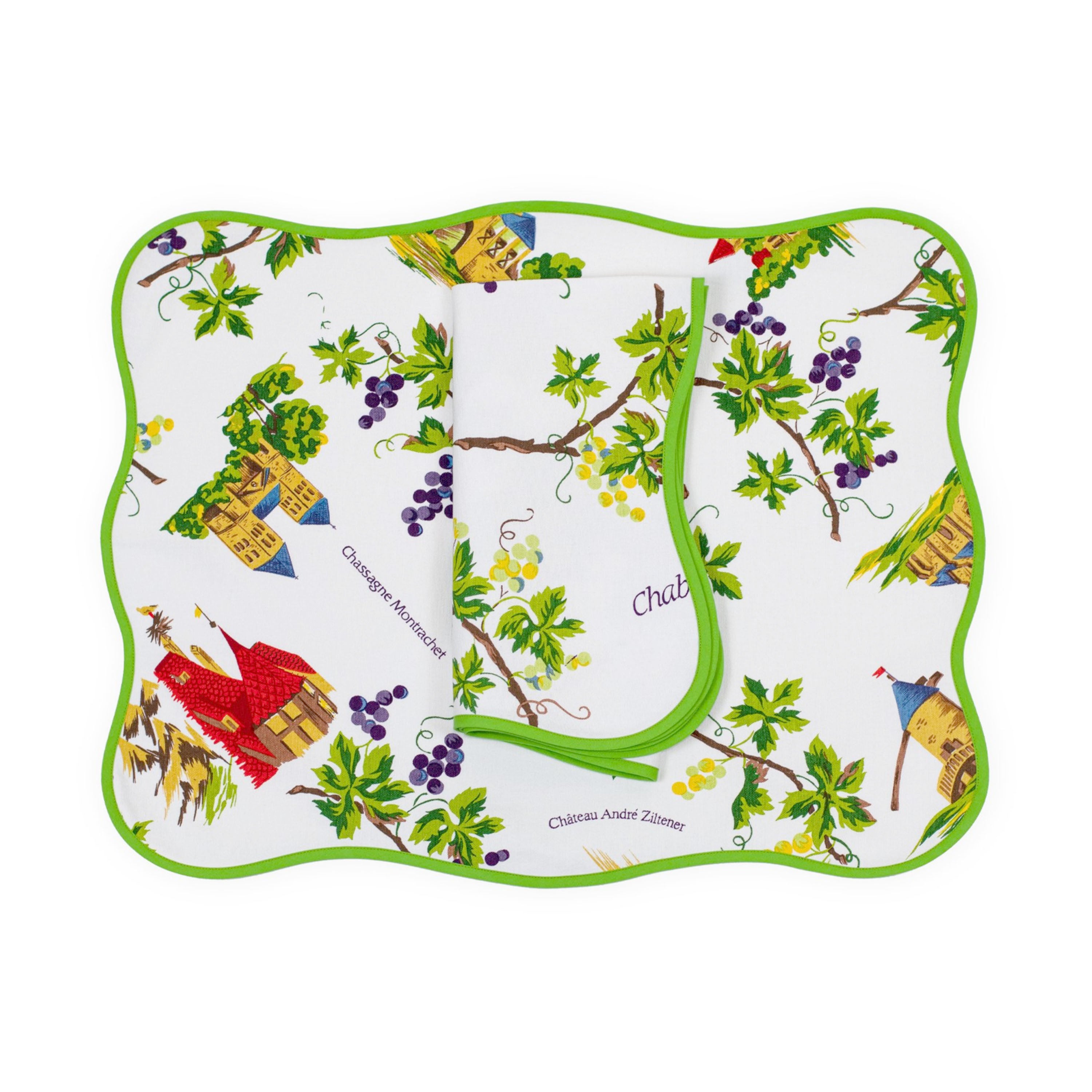 French wine countryside, featuring hand-drawn vineyards, grape clusters, and charming châteaux in vibrant countryside hues. Fresh greens, deep purples, and sunny yellows, words saying: Chassagne Montrachet and Château André Ziltener. Vins de France print, shown on placemat with a folded napkin, finished with a wavy greenbias, on a white background.