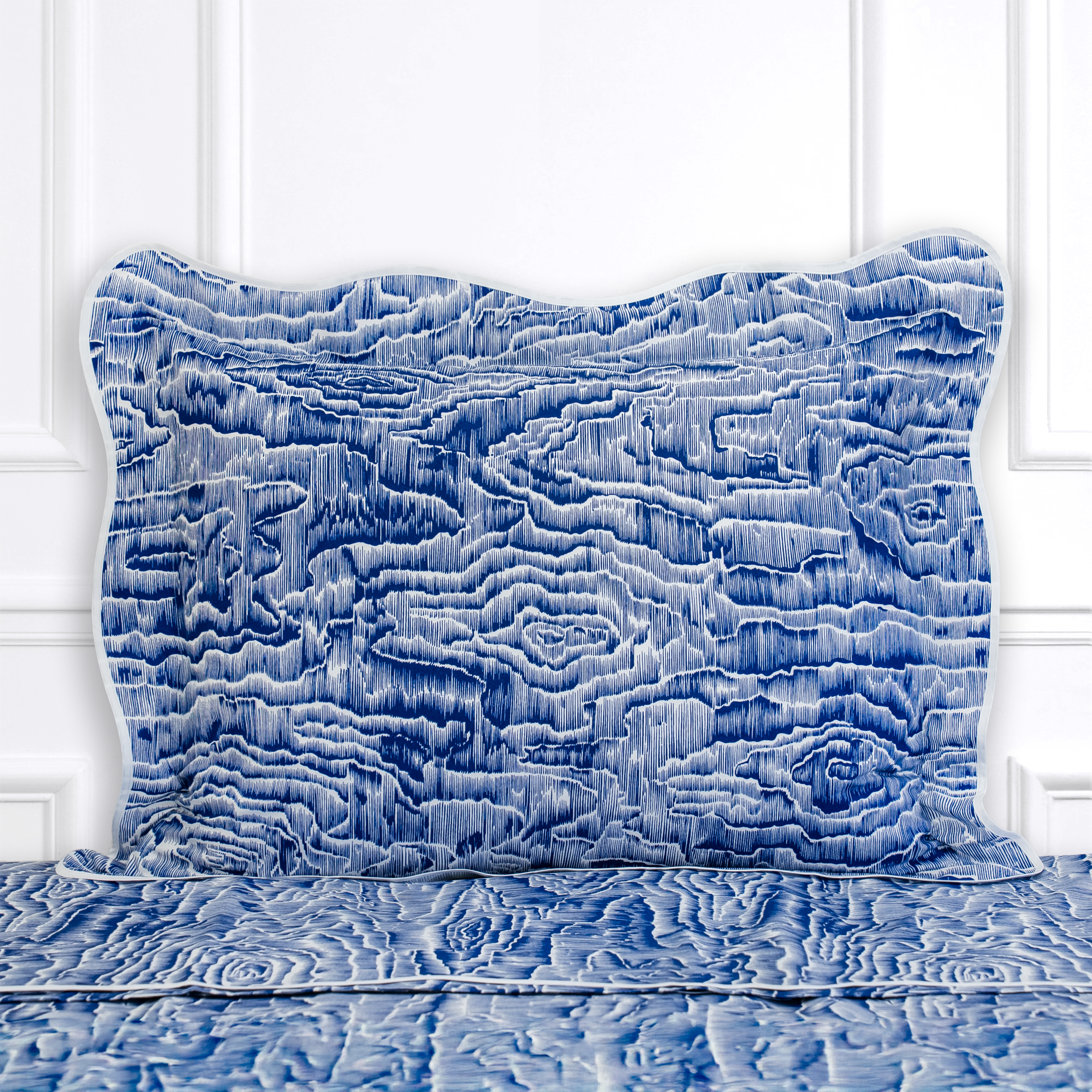 Blue textured bedding set on a white bed frame