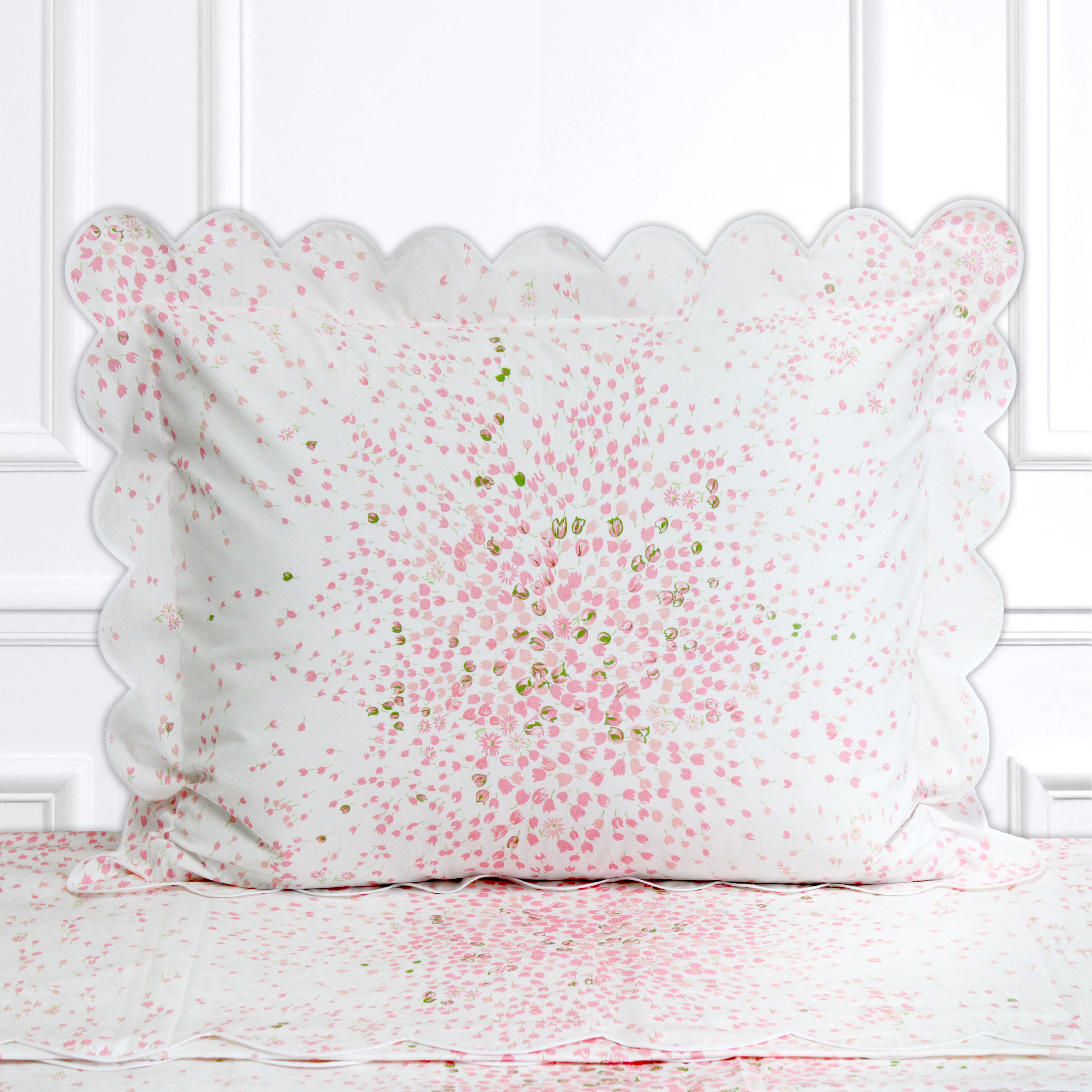 Pink and green florals, Bouquet Eclate print shown on a Standard Sham with a scallop white bias, on top of matching bed sheet with a white panel background.