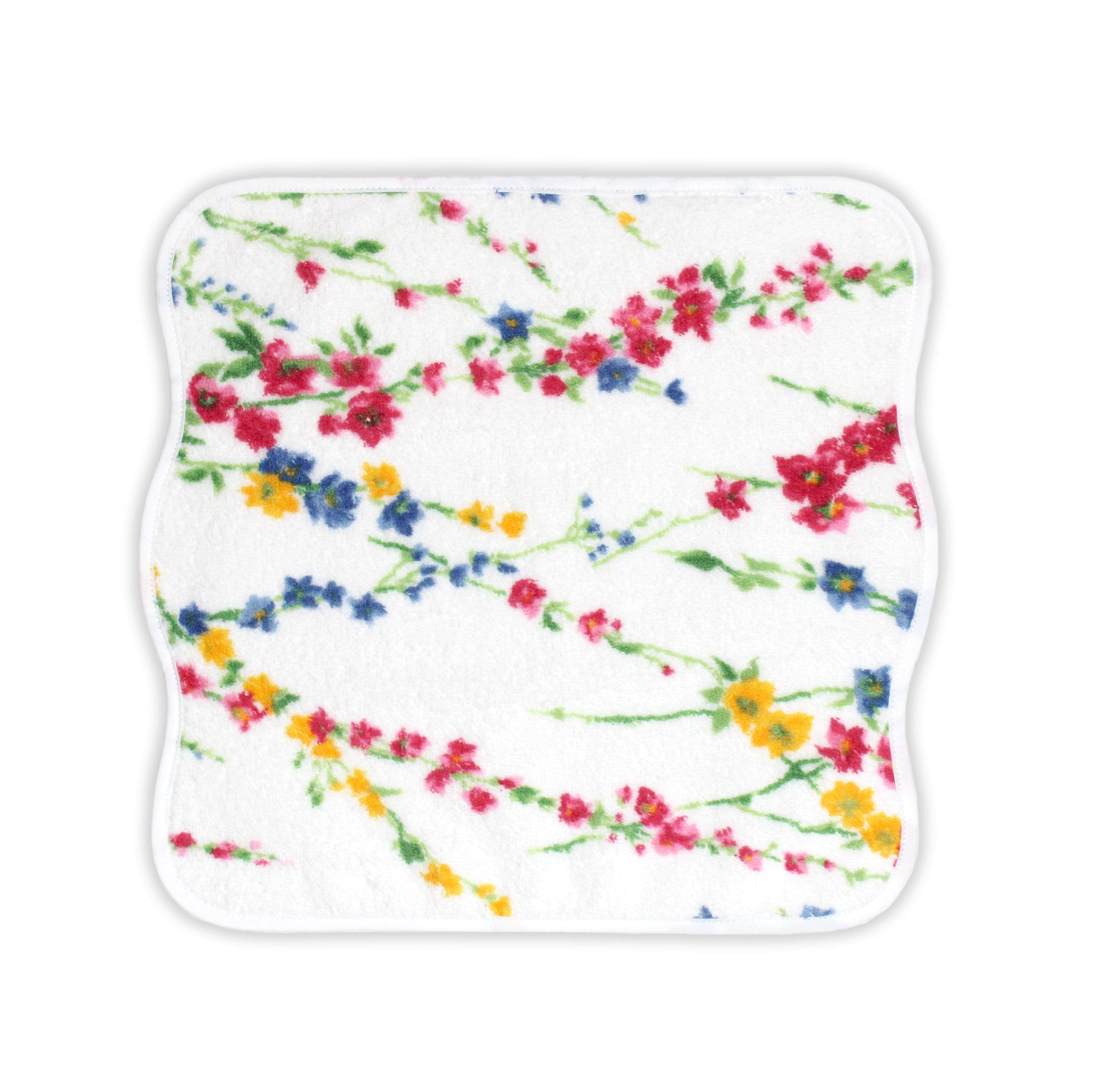 Close up of Printed multi color florals; pink, blue and yellow with green leaves/stems, Brindilles Print, on a Washcloth, with a solid white background.