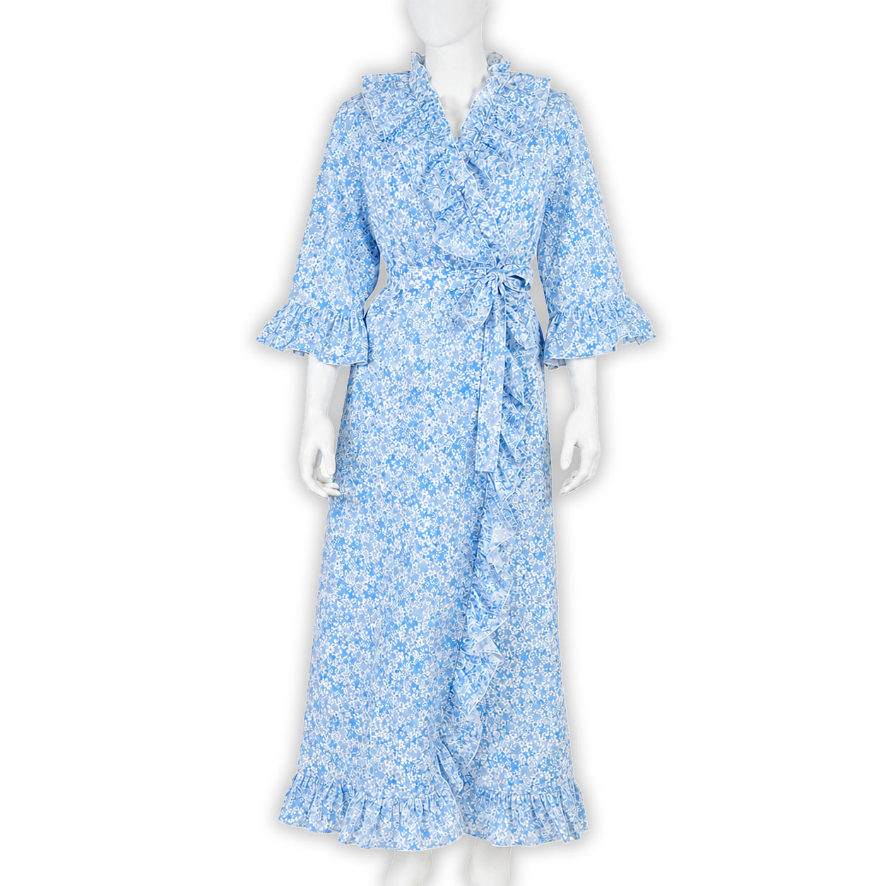 Blue florals on cotton voile bias cut long nightgown with waist tie and V-neck, ruffles in front, back and on sleeve cuffs. Displayed on mannequin with a white background.
