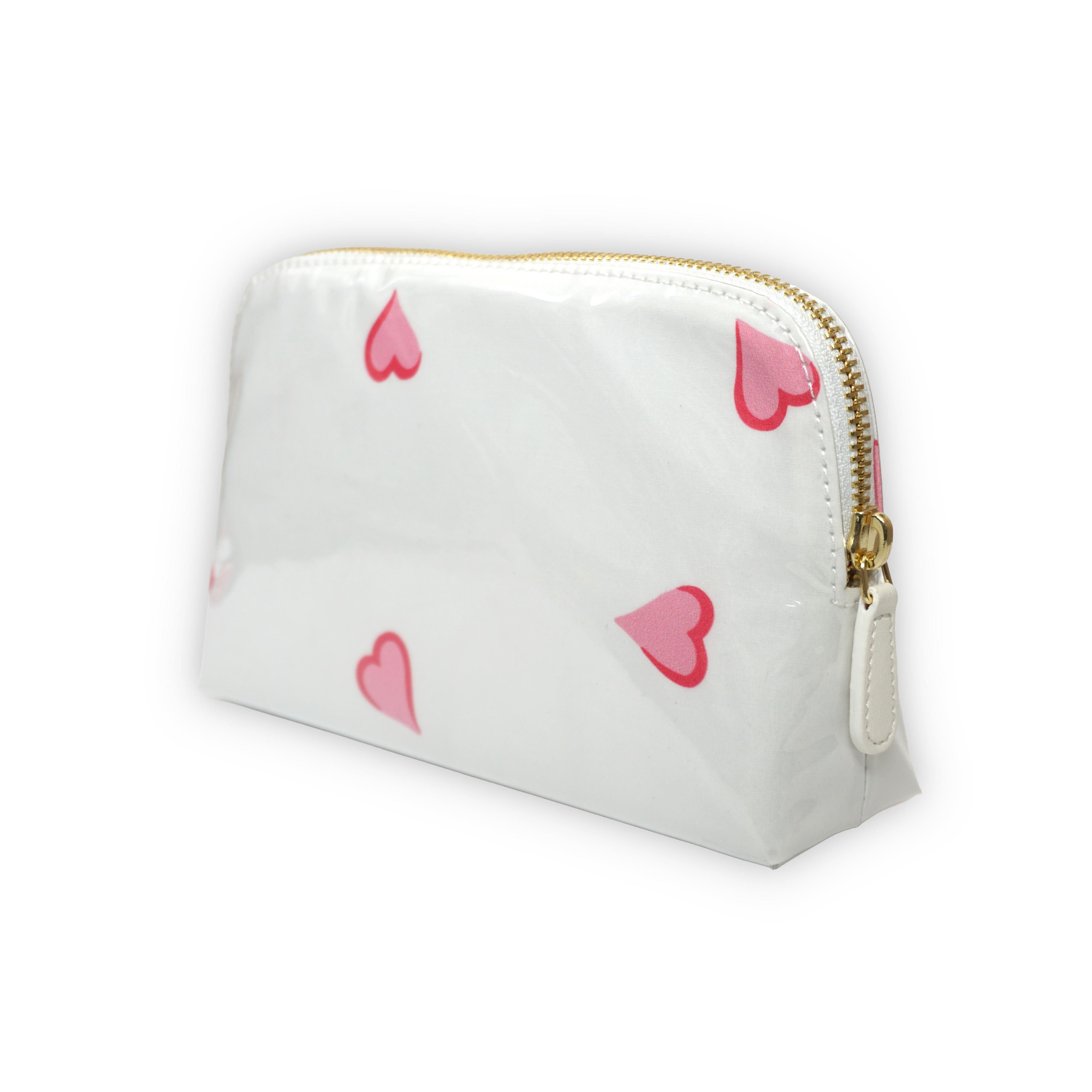 Small white cosmetic pouch featuring scattered pink heart motifs, finished with a gold-tone brass zip closure.