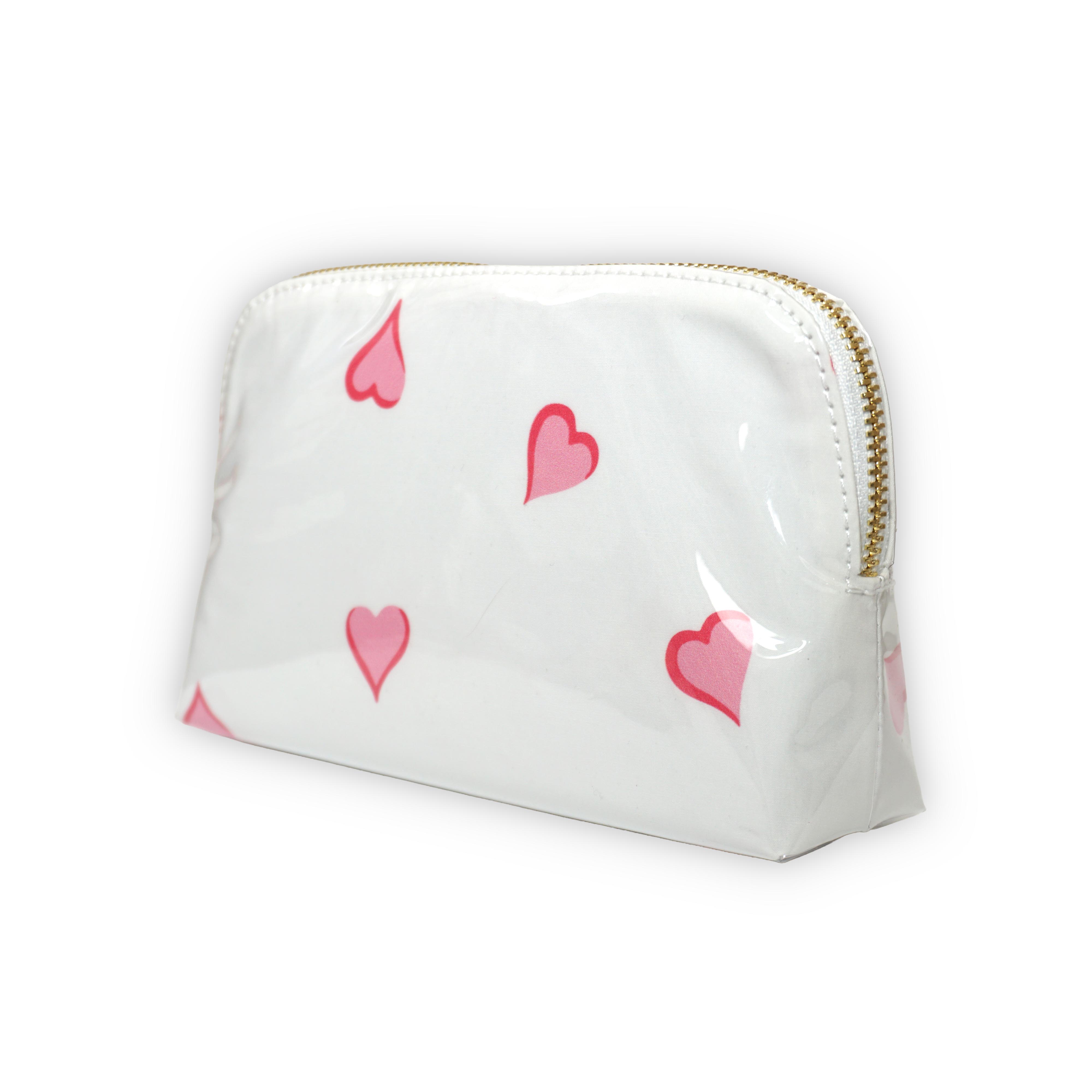 Small white cosmetic pouch featuring scattered pink heart motifs, finished with a gold-tone brass zip closure.