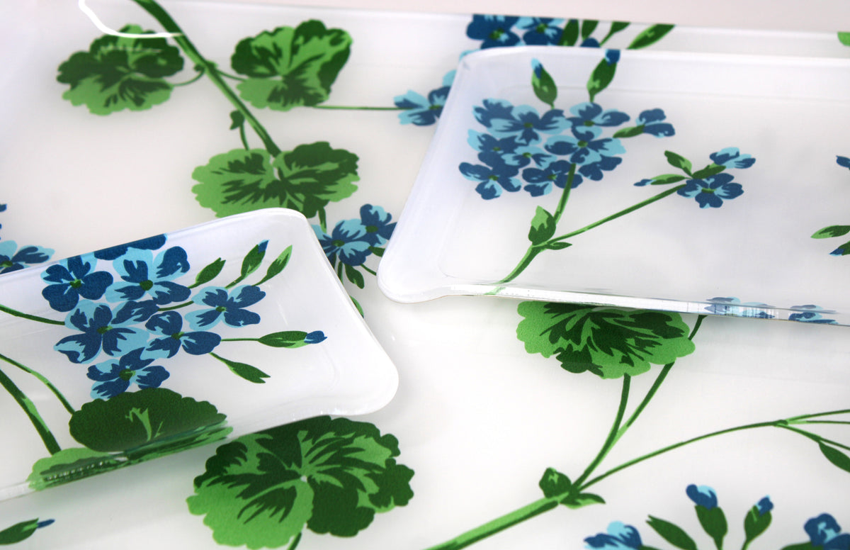 Printed Laminated Trays, side view of small and medium size trays on top of large tray. Each tray in turquoise/blue florals with green leaves/stems, Geraniums print.