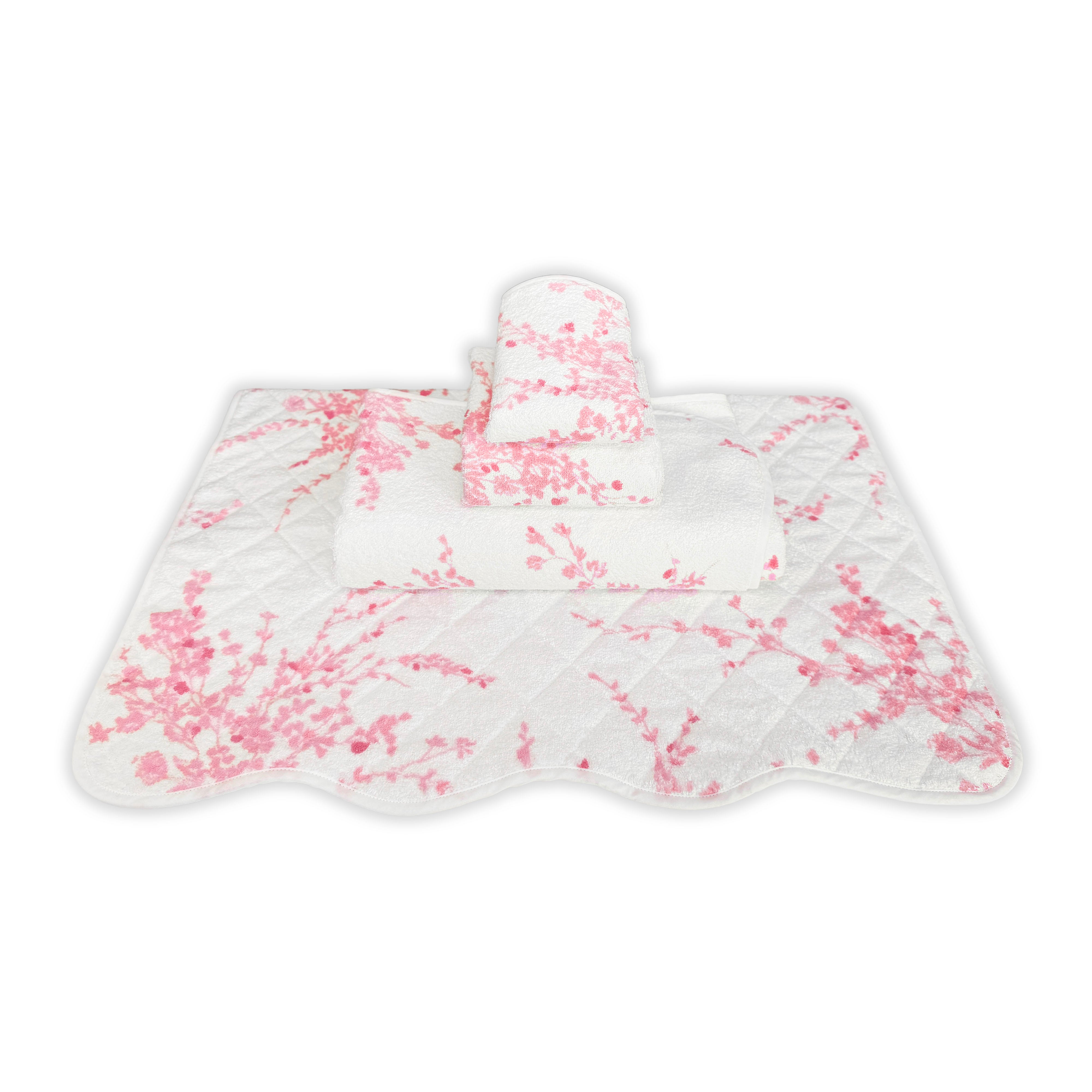 Printed pink floral print, Folded Towel stack. Showing 1 of each size, from bottom to the top: Bathmat, Bath Towel, Hand Towel and Washcloth on a solid white background.