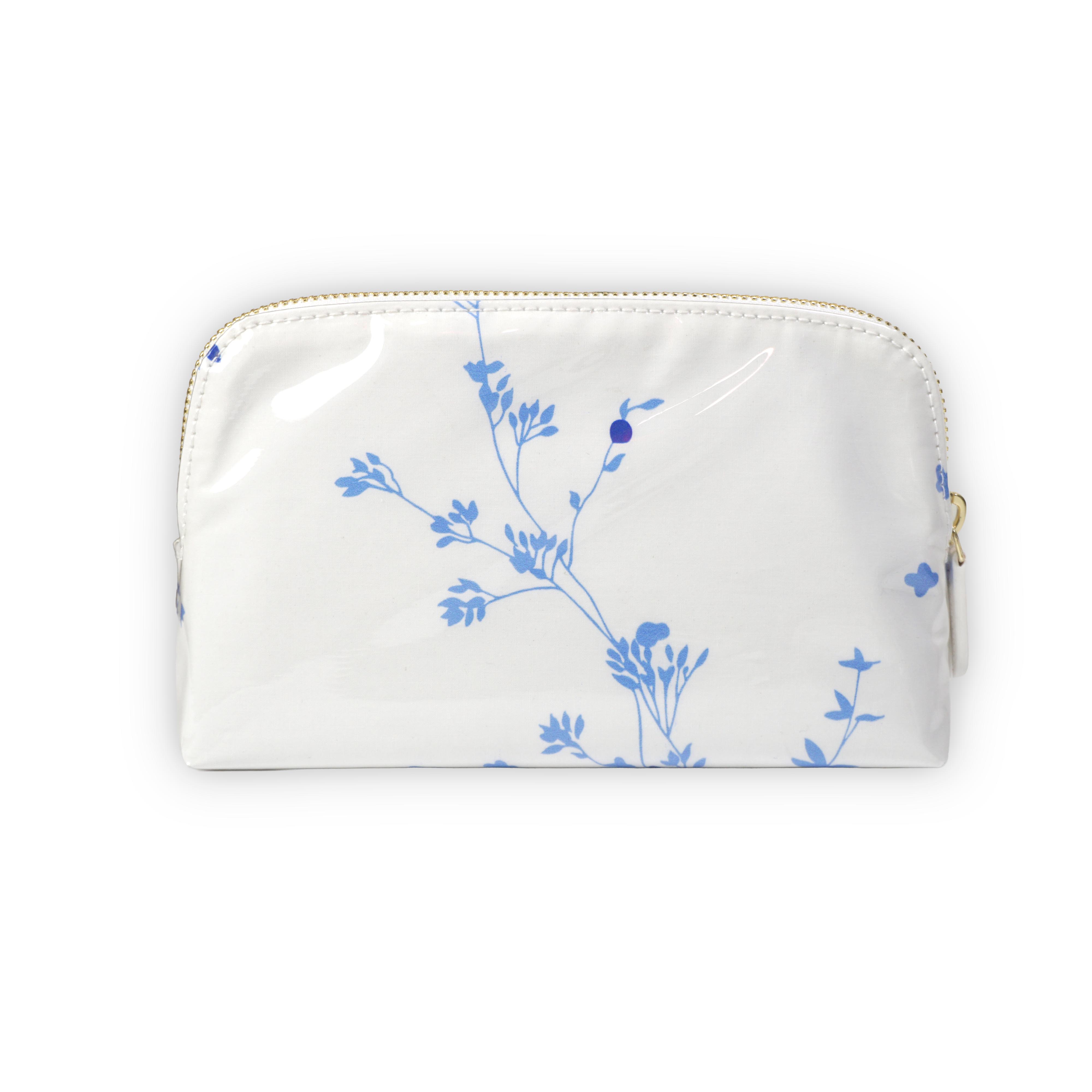 Small white cosmetic pouch featuring blue floral motifs in Jete de Fleurs, finished with a gold-tone brass zip closure.