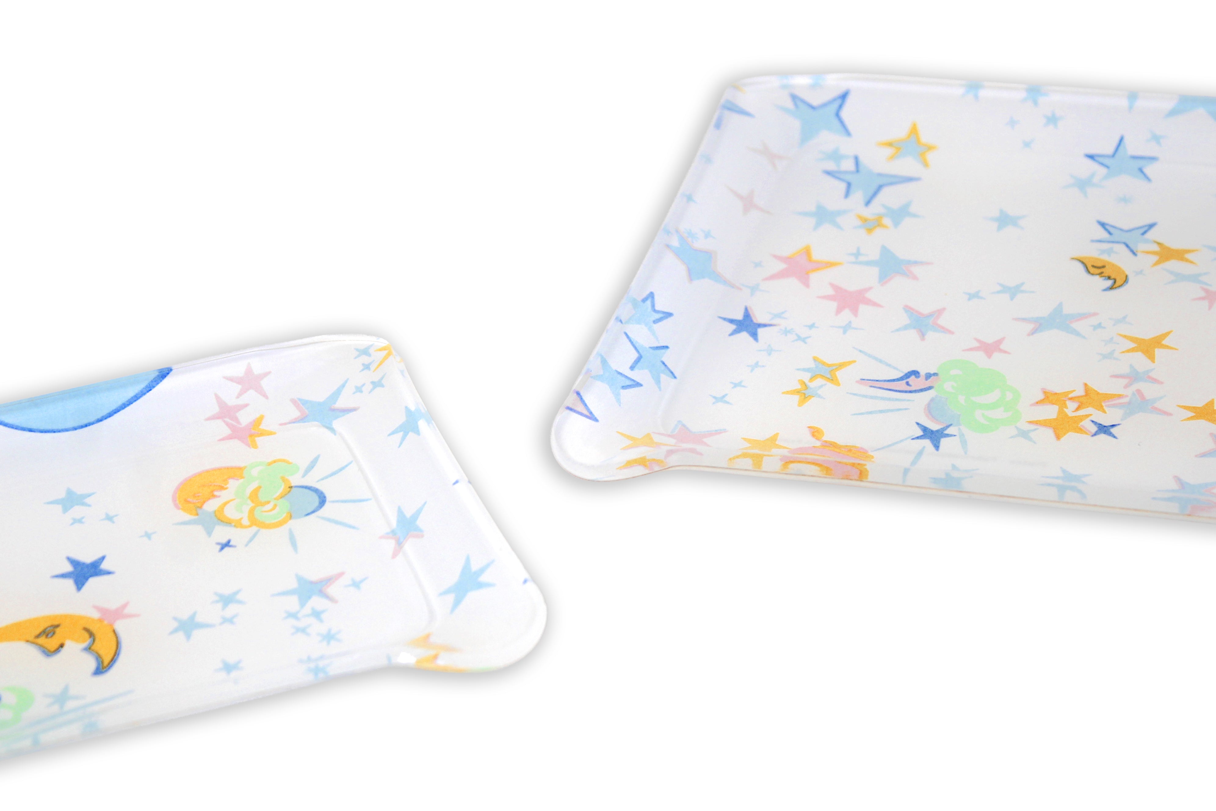 Printed Laminated Trays, side view of small and medium size trays on white background. Each tray with a mix of blue, yellow, pink and green moons and stars. 