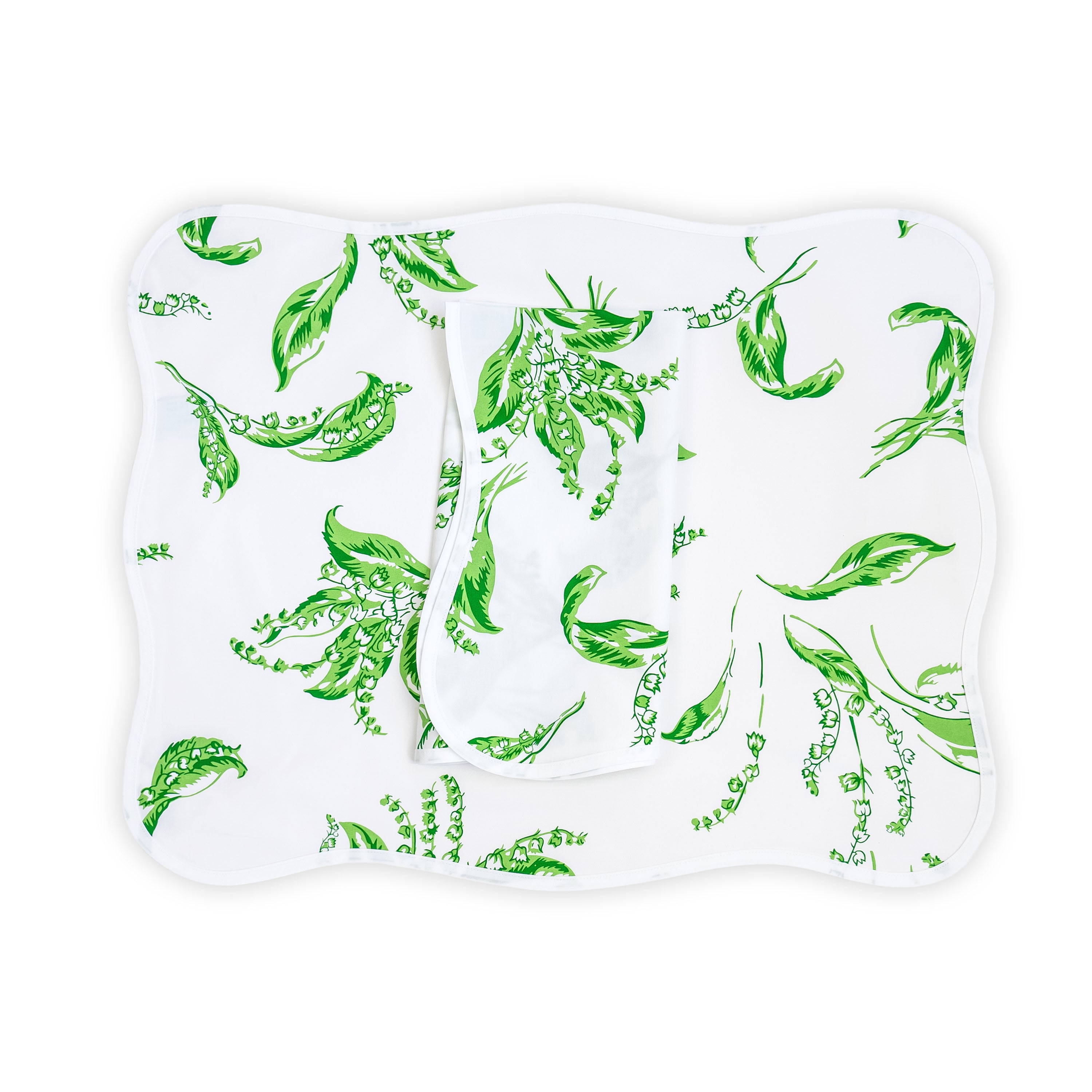 Green lily of the valley florals, Muguet print, shown on placemat with a folded napkin, finished with a wavy white bias, on a white background.