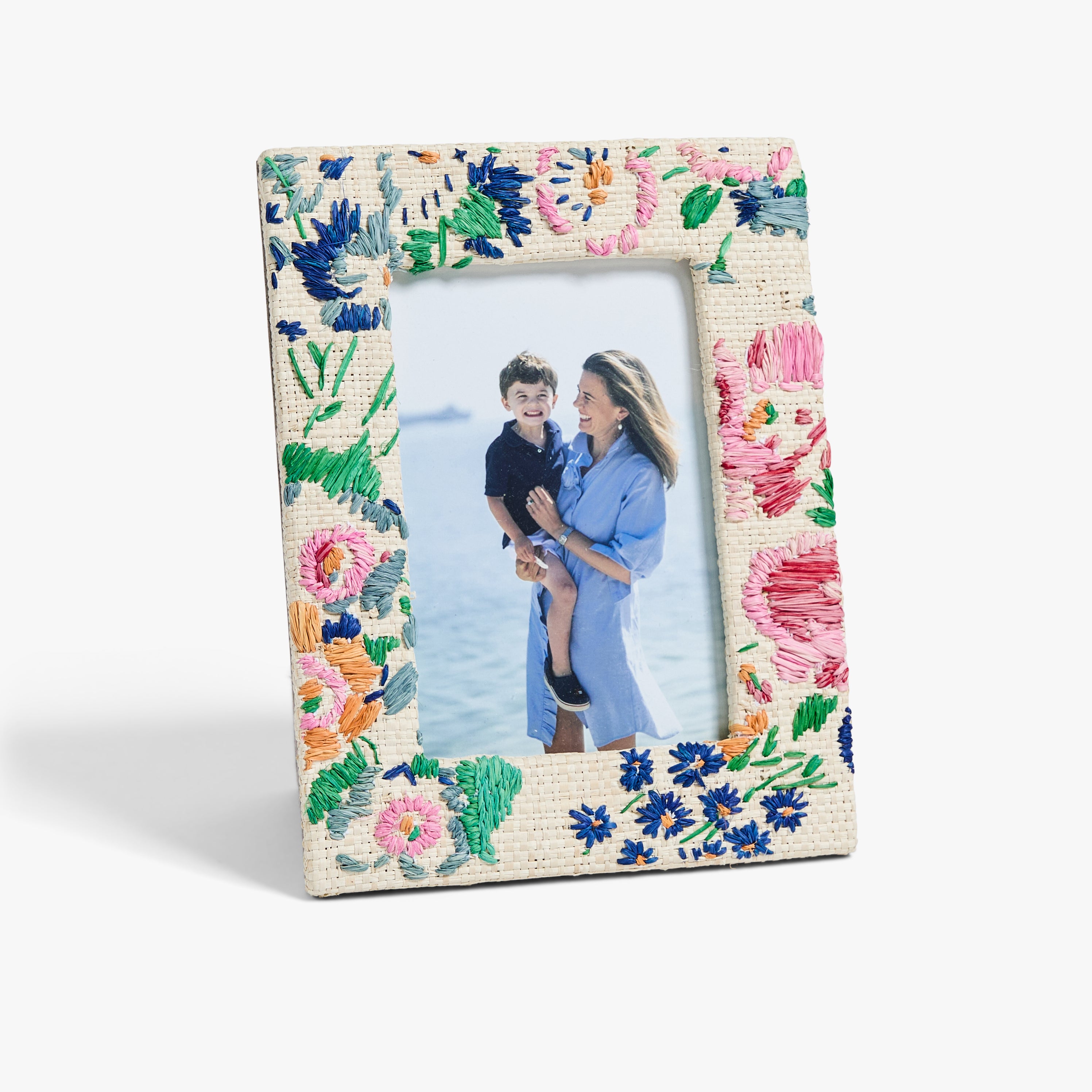 Floral patterned picture frame with a photo of a woman holding a child inside.