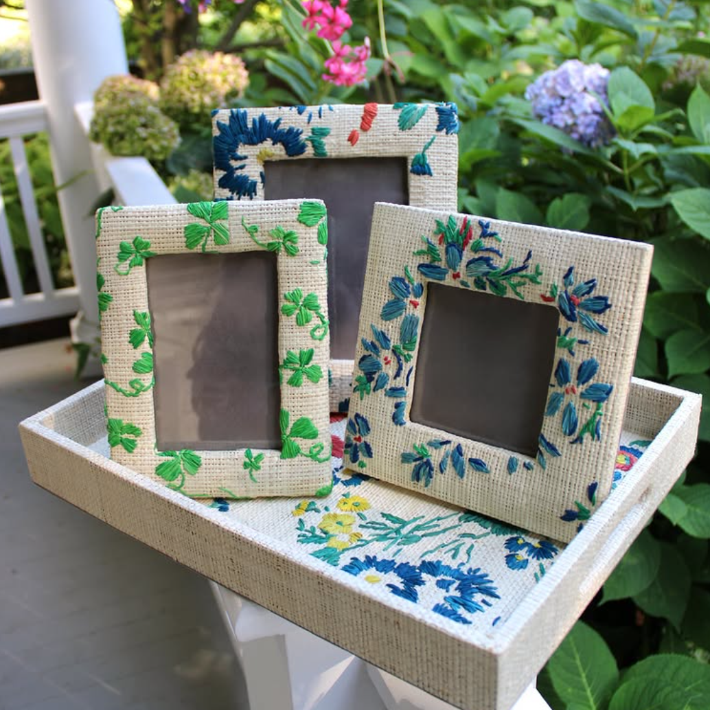 D. Porthault x Pamela Munson Collection of rattan frames, and tray in hand embroidered floral prints.