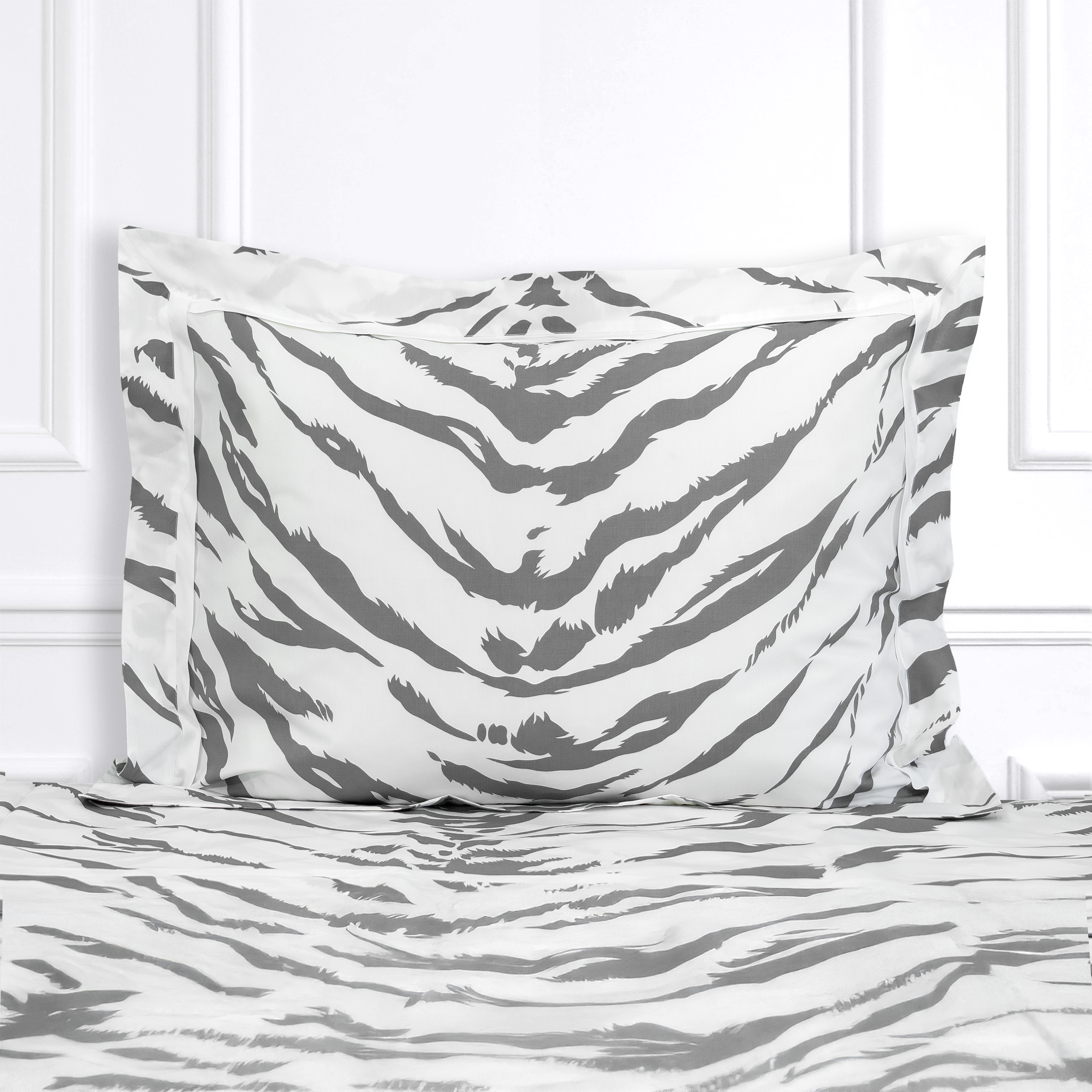 Grey strips on a white background, Tigre print shown on a Standard Sham with a white Passepoil Plat finish, on top of matching bed sheet with a white panel background.