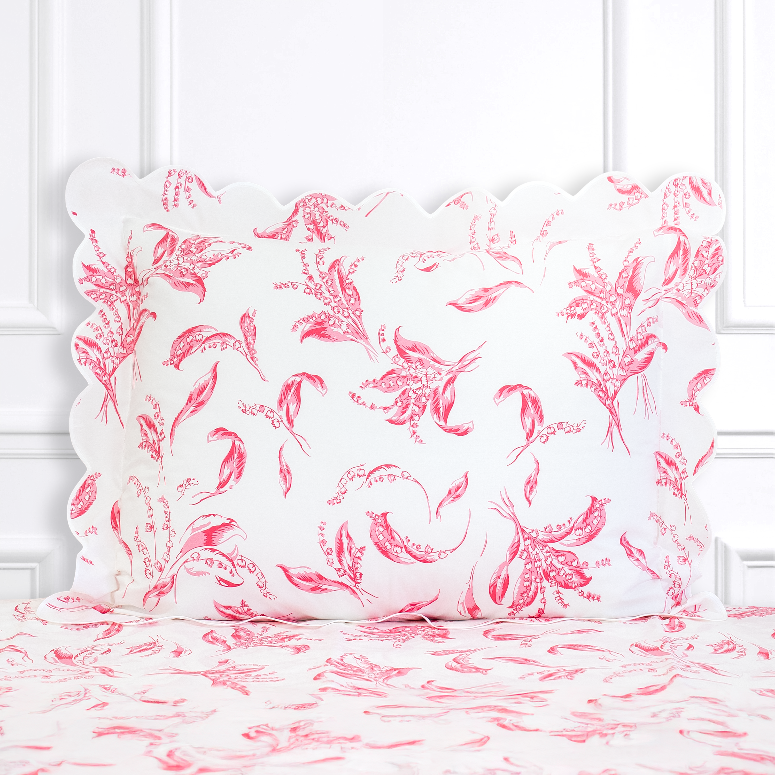Hot pink florals, Muguet print shown on a Standard Sham with a scallop white bias, on top of matching bed sheet with a white panel background.