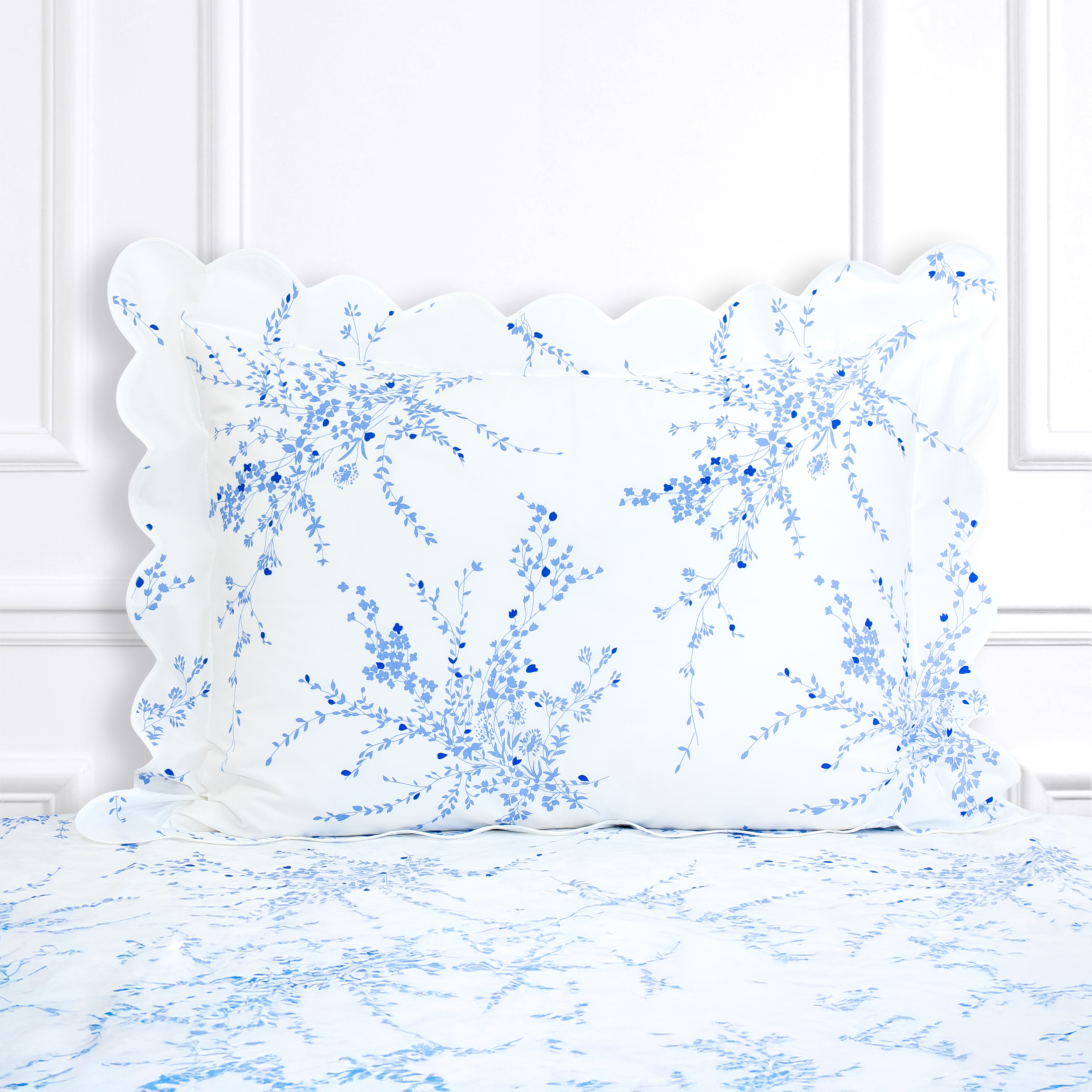 Blue florals, Jete de Fleurs print shown on a Standard Sham with a scallop white bias, on top of matching bed sheet with a white panel background.