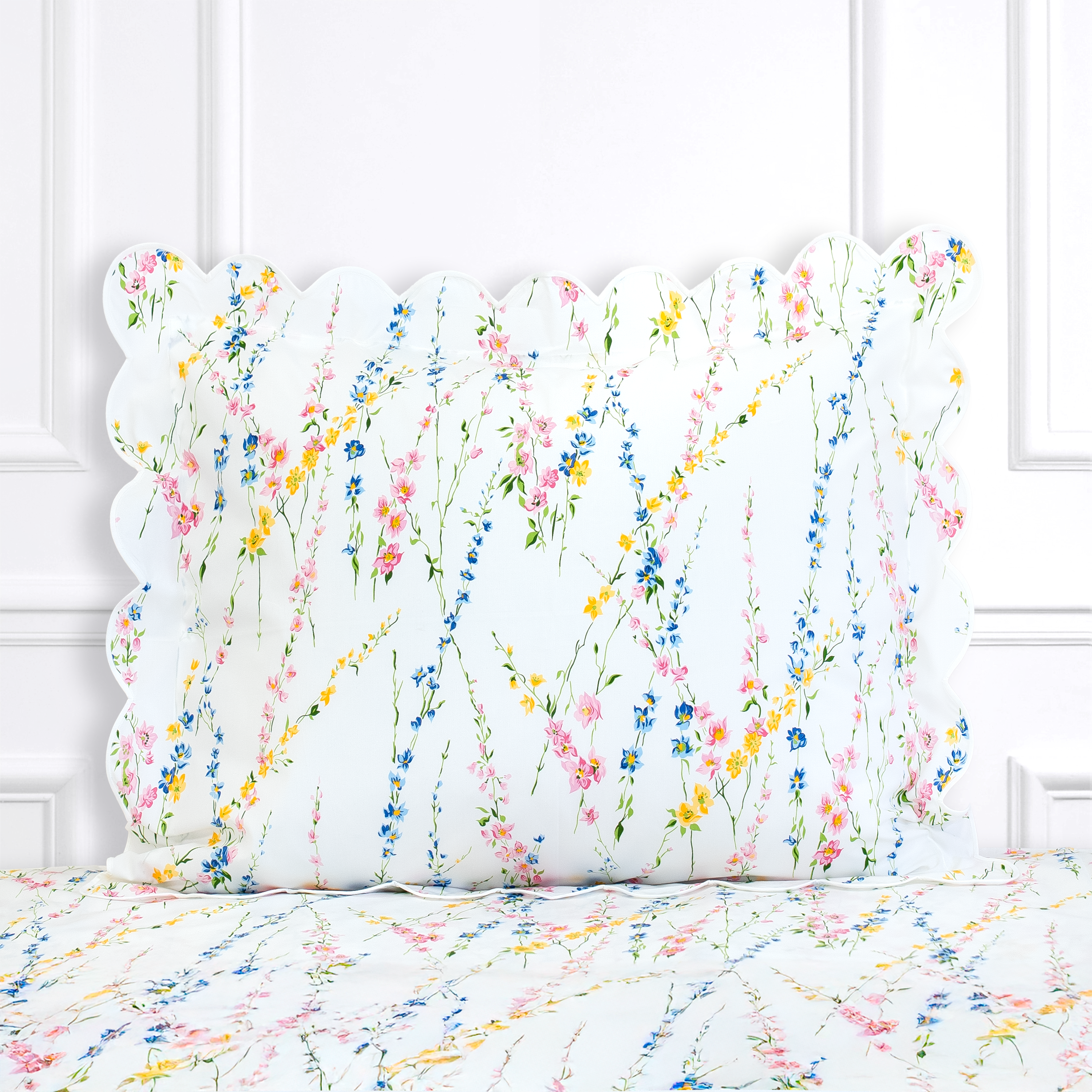 Multi color floral, Brindilles print shown on a Standard Sham with a scallop white bias, on top of matching bed sheet with a white panel background.