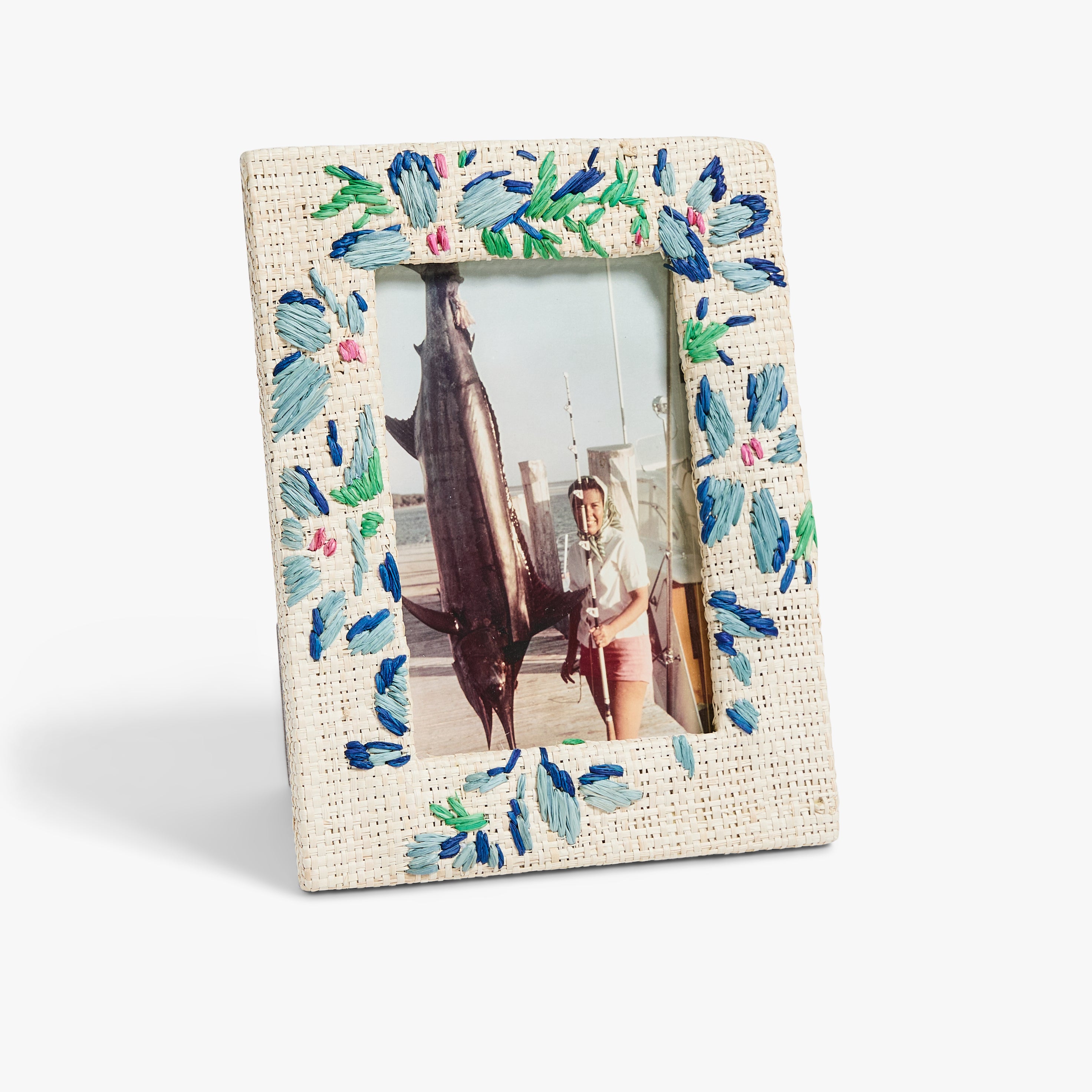 Blue and Green floral photo frame with colorful embroidered flowers, holding an image of a person proudly posing with a large fish on a dock. 