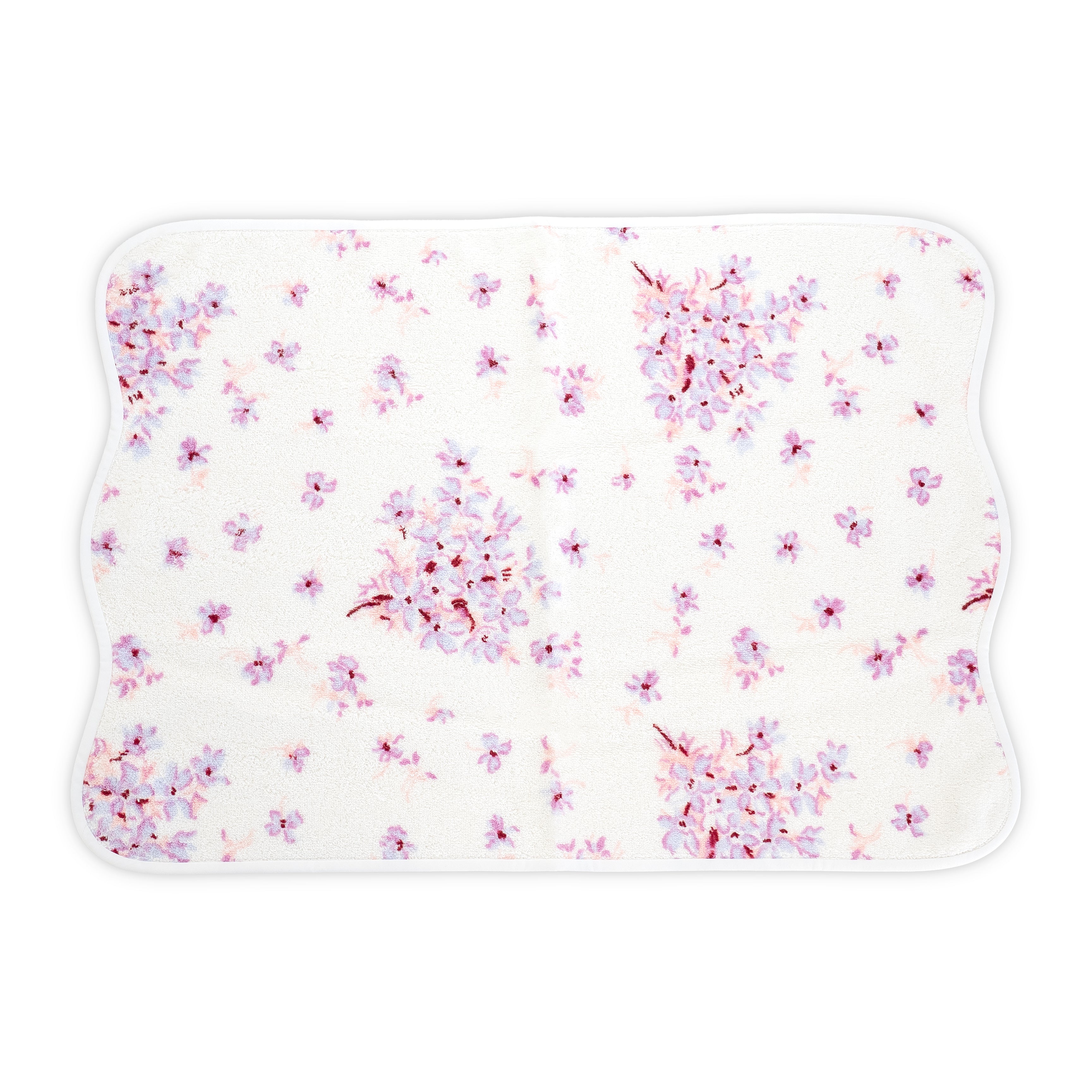 White Hand towel with violet and pink floral print. Hand towel shows with a wavy white bias. On a white background.