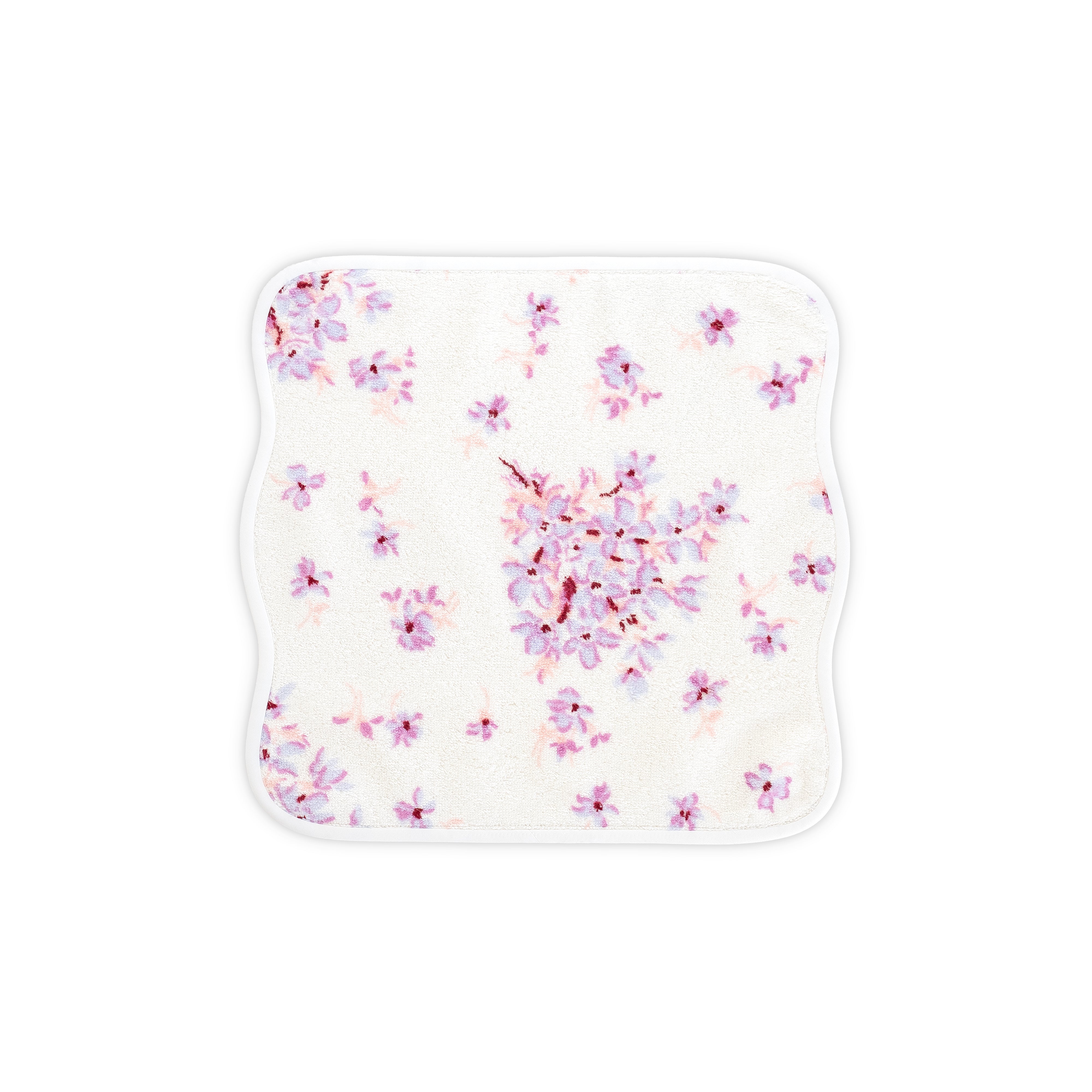 White washcloth with violet and pink floral print. Washcloth shows with a wavy white bias. On a white background.